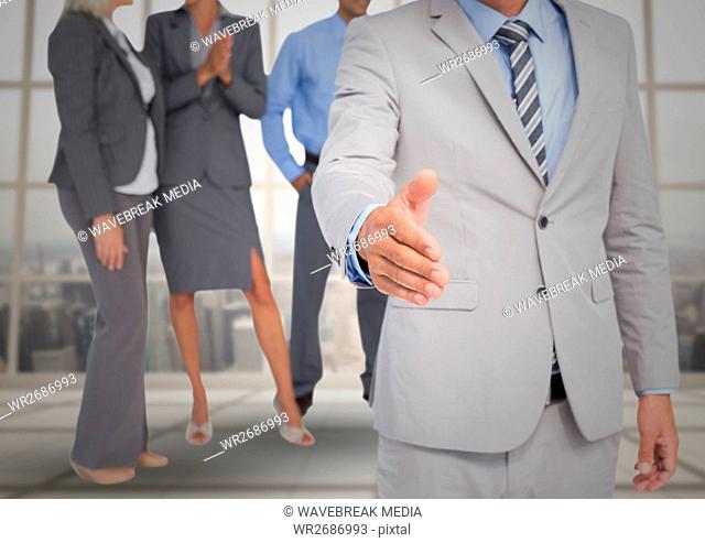Handshake in front of business people at window