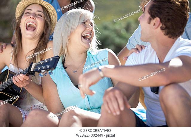 Friends with guitar having fun outdoors