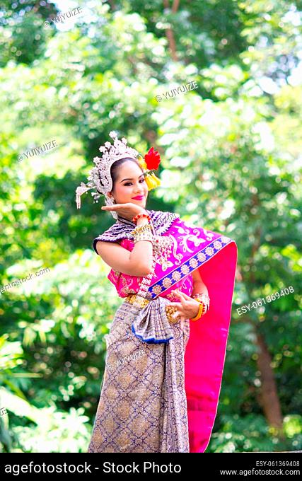 Asian woman wearing typical, traditional Thai Dress. It is literally means ""Thai outfit"", National silver and pink costume