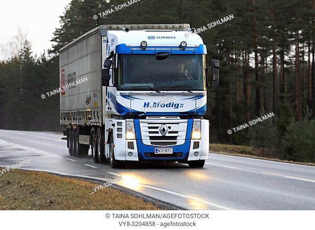 SALO, FINLAND - DECEMBER 8, 2017: Blue and white Renault Magnum truck of Helmer Modig Oy pulls DB Schenker trailer along wet highway in early winter