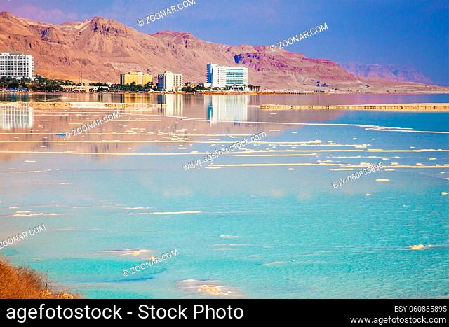 The concept of medical and ecological tourism. The Dead Sea resort in Israel. Turquoise smooth water and midday heat