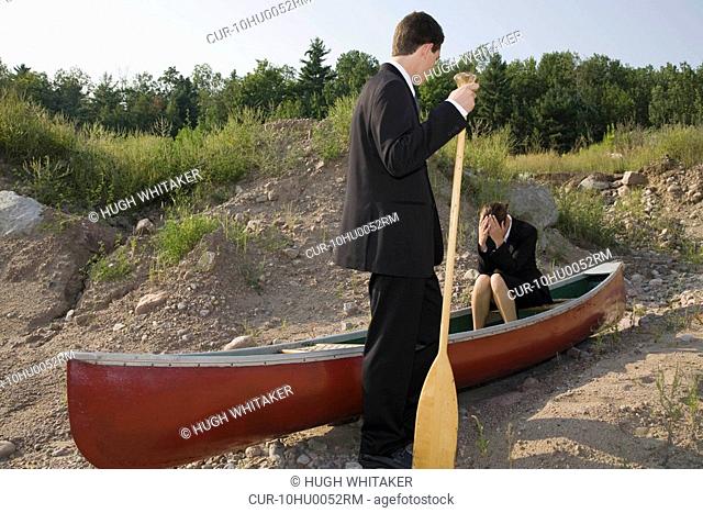 Business people in stranded canoe