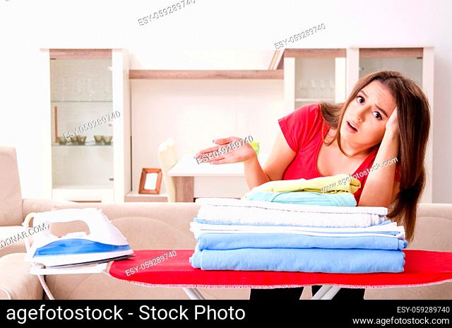 Young beautiful woman ironing at home