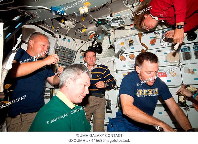 The four STS-135 crewmembers, quite accustomed to going en masse to the International Space Station, reverse roles for the occasion of the All-American Meal on...