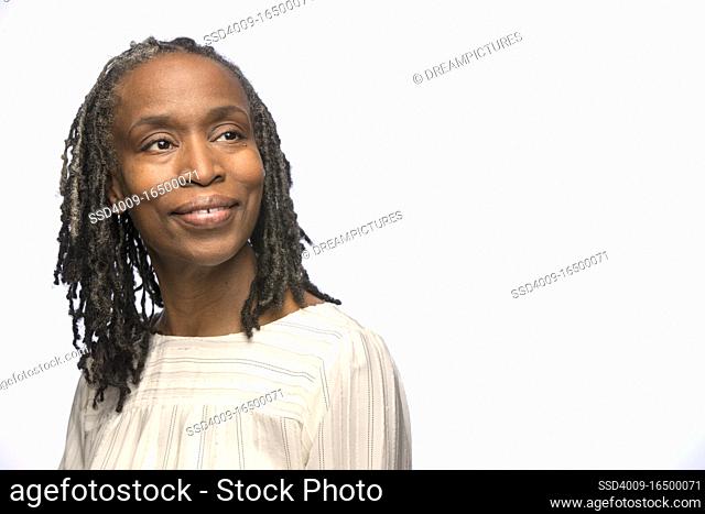 Portrait of middle aged black woman looking off camera with smile