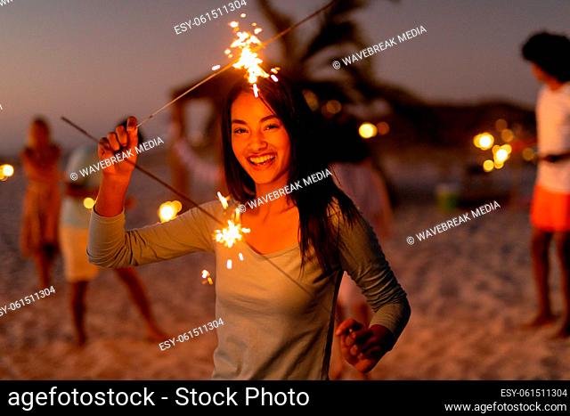 Multi-ethnic group of male and female dancing with firework stick
