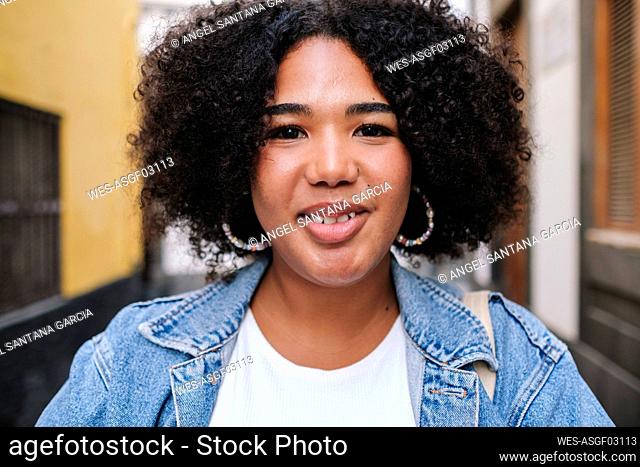 Smiling young woman with curly hair