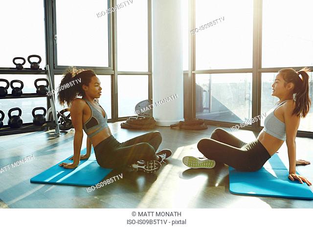 Two young women exercising in gym