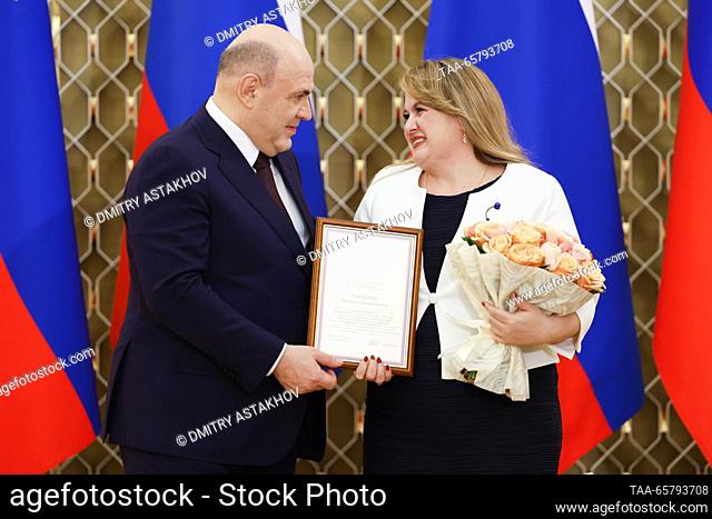RUSSIA, MOSCOW - DECEMBER 15, 2023: Russia's Prime Minister Mikhail Mishustin (L) awards senior lecturer Marianna Charuiskaya at the Moscow State University of...