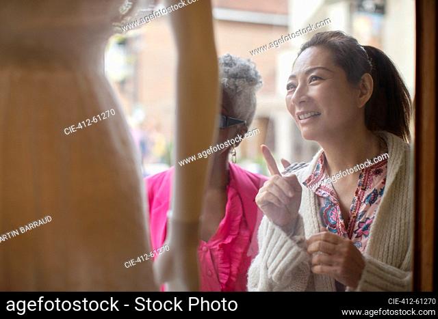 Women window shopping at storefront