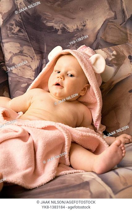 Happy Emotional Eight Month Old Infant Girl Sitting in Bathrobe