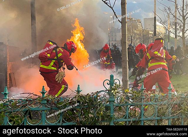 FRANCE, PARIS - APRIL 6, 2023: Firefighters battle a fire during a mass protest against the controversial pension reform proposed by the French government;...