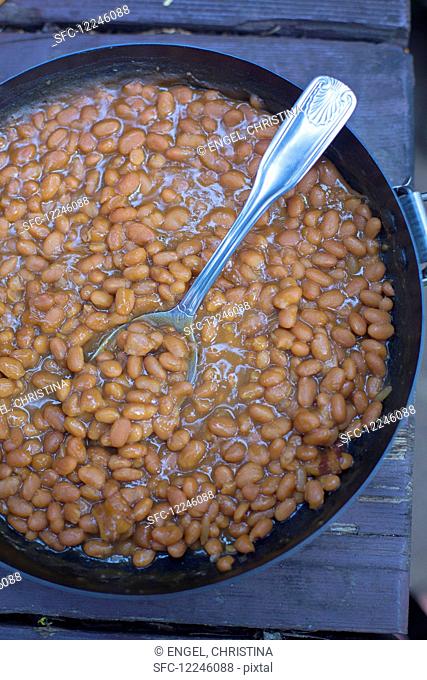Baked beans in a pan on a wooden table