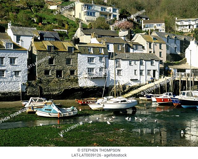 A traditional coastal fishing village, with small houses and harbour at low tide. Fishing and pleasure boats