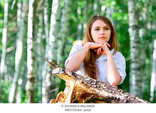 Young woman relaxing in the birch forest