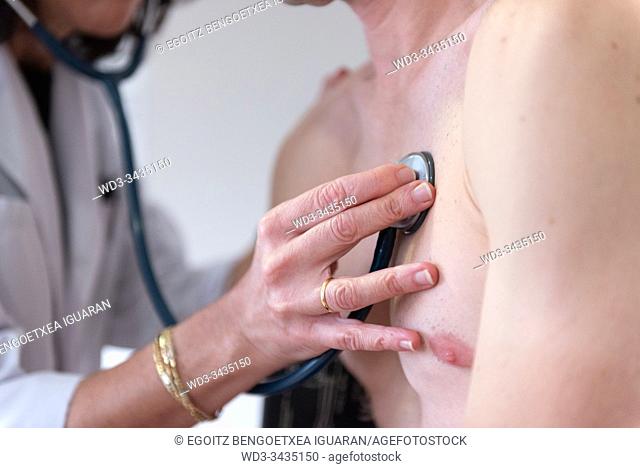 A female doctor checking the heart health of a man with a stethoscope