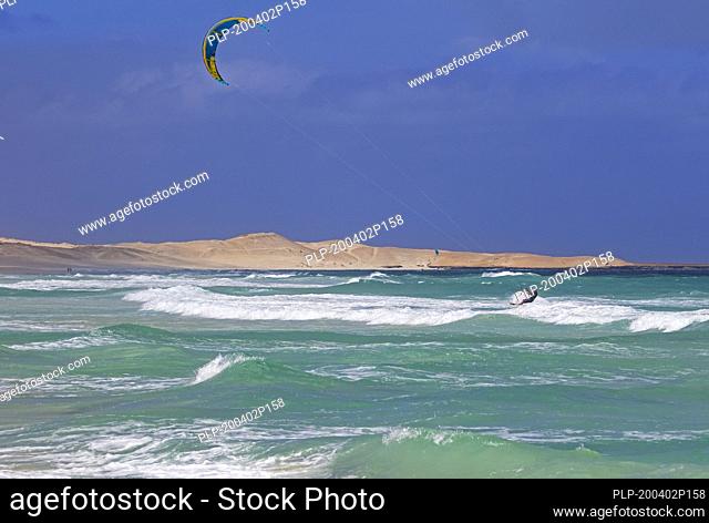 Kitesurfer / kiteboarder pulled by power kite at Rabil beach on the island Boa Vista, Cape Verde / Cabo Verde archipelago in the Atlantic Ocean