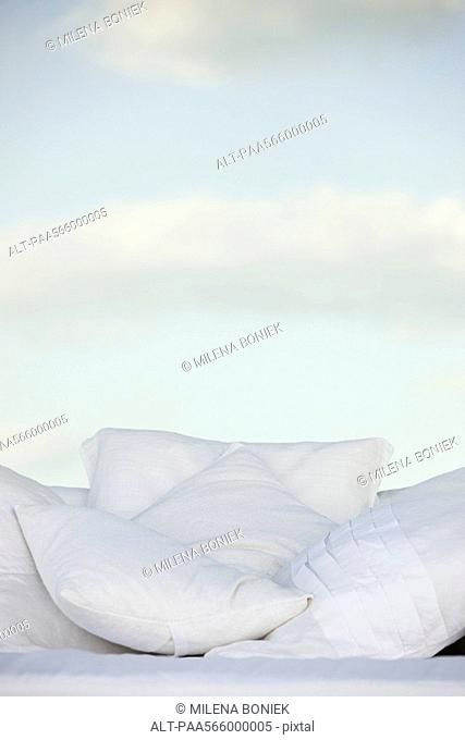 Pillows against background of clouds in pale sky