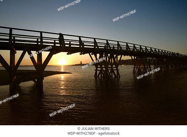 Desternation Spain (South) Isla Christina .The wooden bridge at twilight which joins the main beach to the town