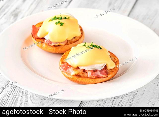 Eggs Benedict with bacon on white plate