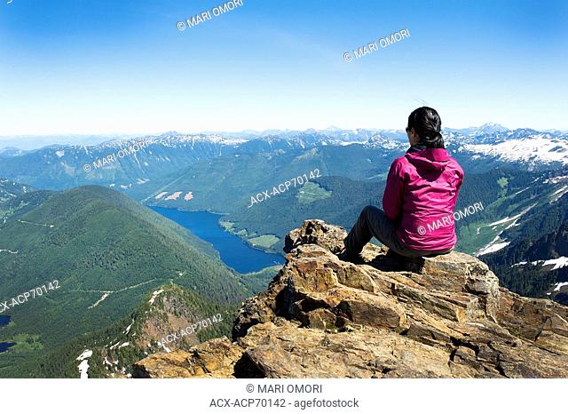 Hiker at the top of Mount Cheam (Cheam Peak) looking down towards Wahleach Lake, Chilliwack, BC. Model Release signed