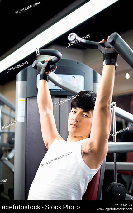 young handsome man works out in modern gym