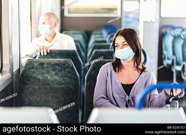 Serious passengers in protective masks during their train day trip