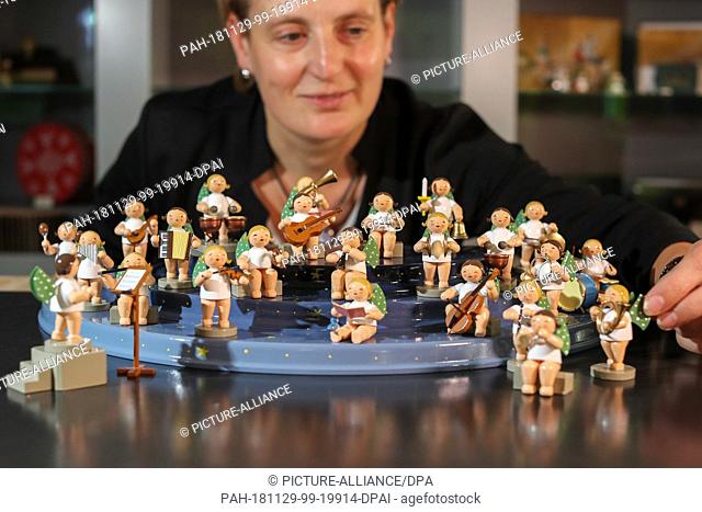 08 November 2018, Saxony, Grünhainichen: An employee of the Wendt&Kühn manufactory presents a mountain of angels with figures of angels from Grünhainich