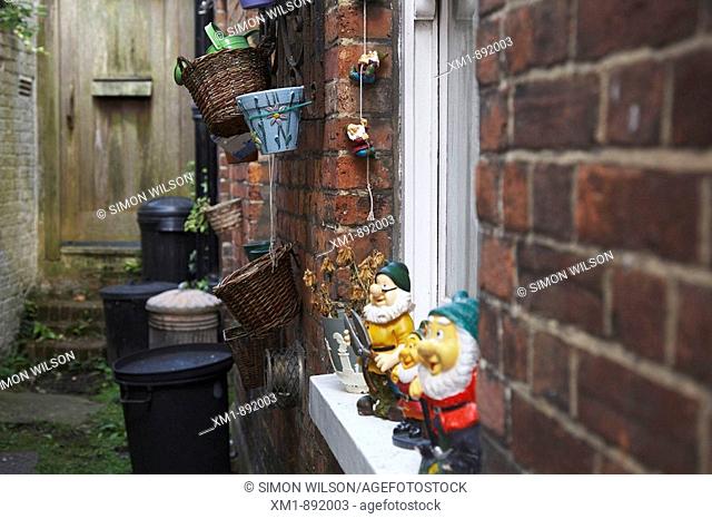 Alleyway with garden gnomes and refuse bins