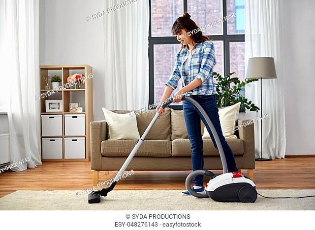 asian woman with vacuum cleaner at home
