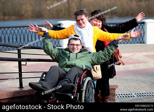 Disabled in a wheelchair with family in the park.A man with his family in a wheelchair