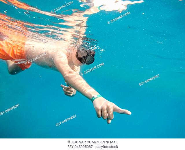 Young boy snorkel swim in underwater exotic tropics paradise with fish and coral reef. Marsa alam, Egypt. Summer holiday vacation concept