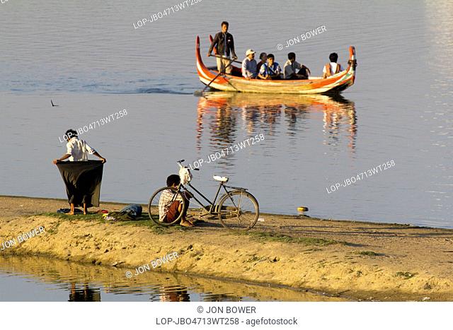 Myanmar, Mandalay, Lake Taungthaman. A tourist boat and passers-by on Taungthaman Lake in Myanmar
