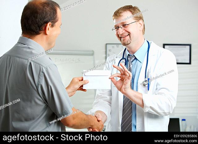 Medical office - patient bribing doctor, giving money in envelope