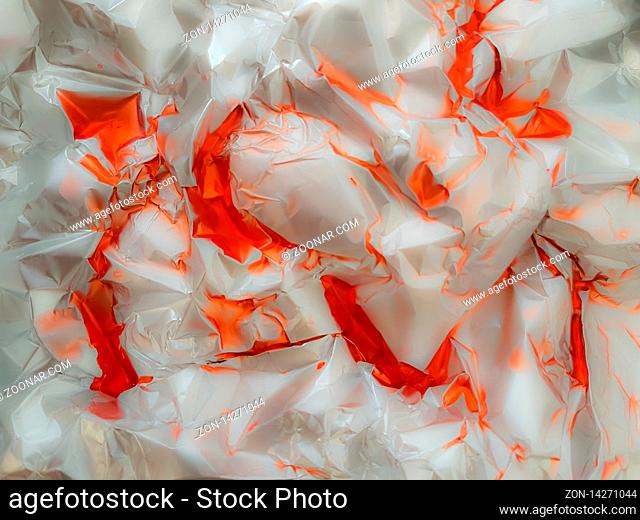 Red paint on crumpled foil with blur as close-up