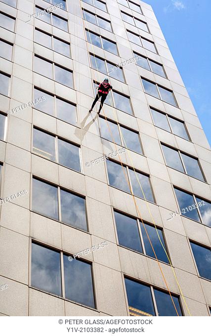 Person repelling down the side of an office building
