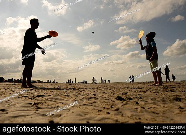 14 August 2021, Lower Saxony, Dangast: Jan plays beachball with his son Jona on the beach of Dangst in nice weather. Photo: Mohssen Assanimoghaddam/dpa