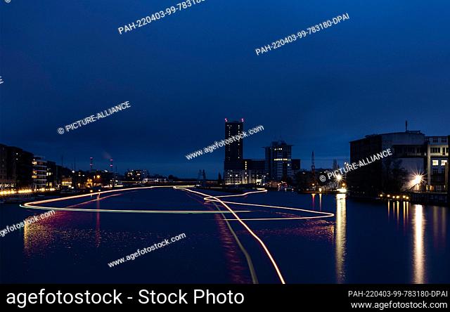 03 April 2022, Berlin: Ships and boats on the Spree can only be seen as light streaks as seen from the Oberbaumbrücke in the direction of the Elsenbrücke