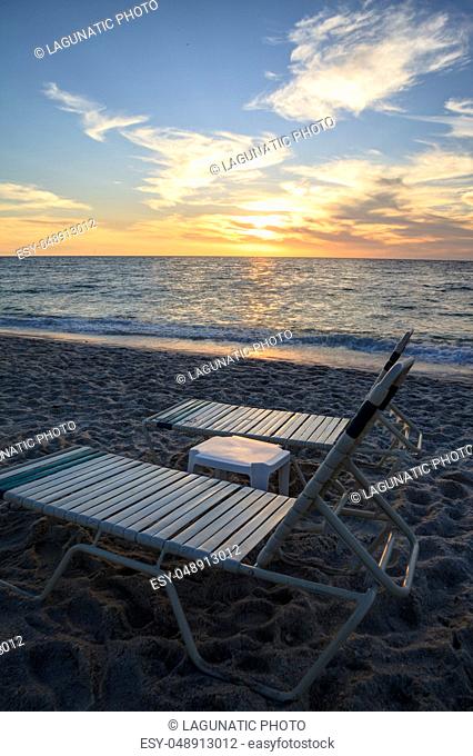 Chairs along Vanderbilt Beach in Naples, Florida, USA at sunset