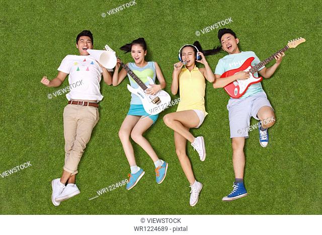 Young people on grass playing musical instruments