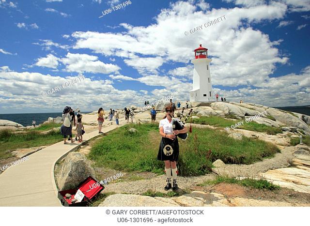 A girl playing the bagpipes in front of the Peggy's Cove Lighthouse