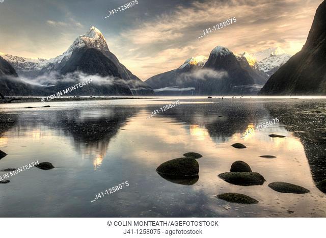 Mitre peak, winter dawn, cold mist rising from Milford Sound, Fiordland National Park