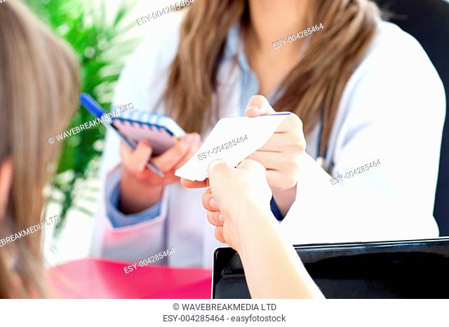 Radiant female doctor giving a paper to her patient