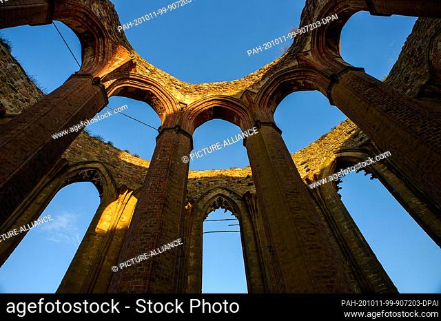 07 October 2020, Saxony-Anhalt, Zerbst: The last light of the day falls on empty Gothic windows in the choir of the ruins of the church of St. Nicolai