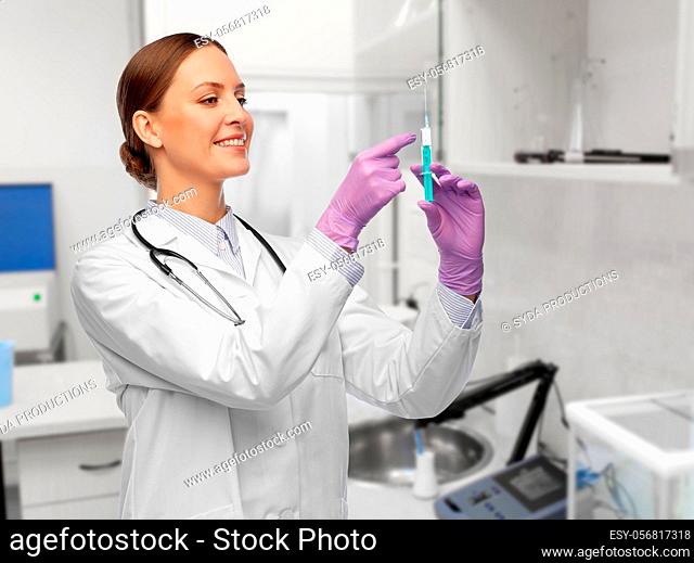 happy female doctor with syringe at hospital