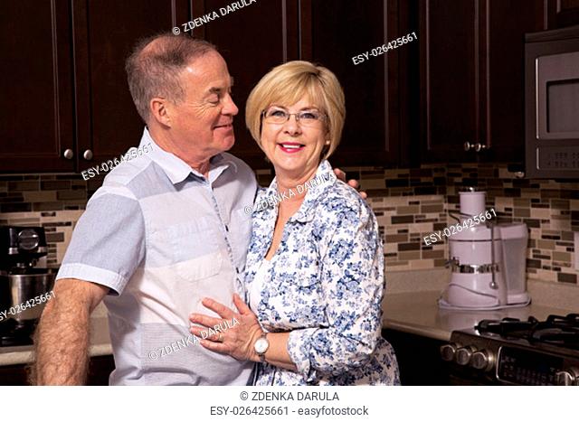 retired couple wearing casual outfits in the kitchen