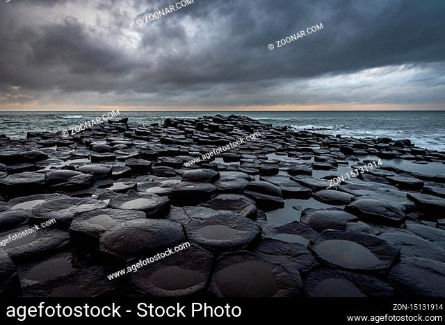 The natural hexagonal stones at the coast called Giant's Causeway, a landmark in Northern Ireland with dramatic cloudy sky
