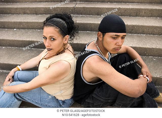 Young Hispanic couple, the woman eight months pregnant, sitting together