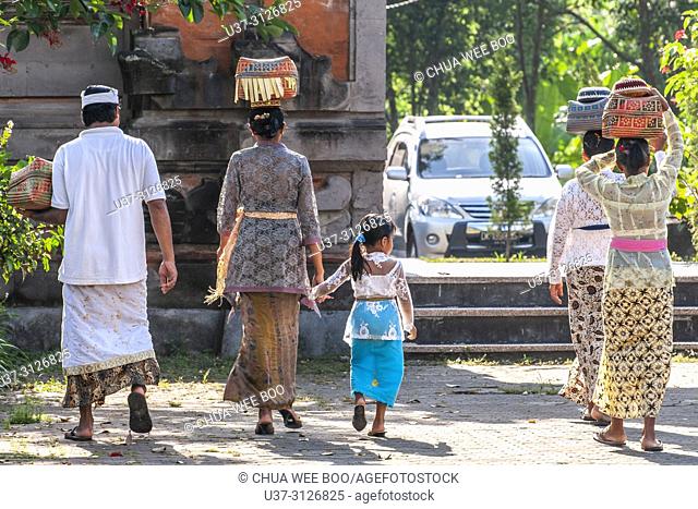 Goa Gajah The Elephant Cave (Bali, Indonesia): women in traditional dress, carrying a basket with offerings on their heads