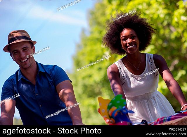 a young man and a beautiful black girl enjoying a bike ride in nature on a sunny summer day